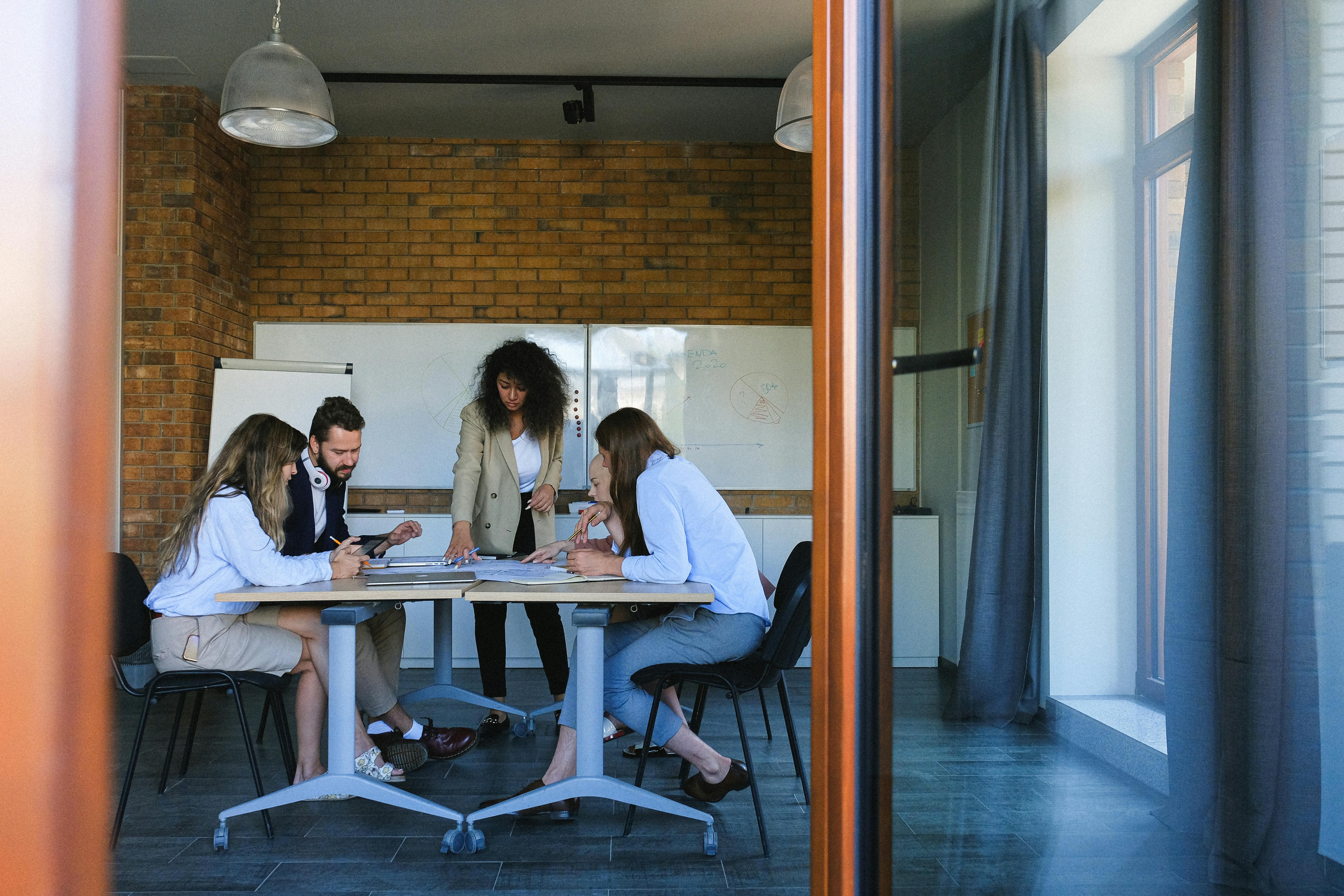 Team working together around a conference table seen through an open doorway